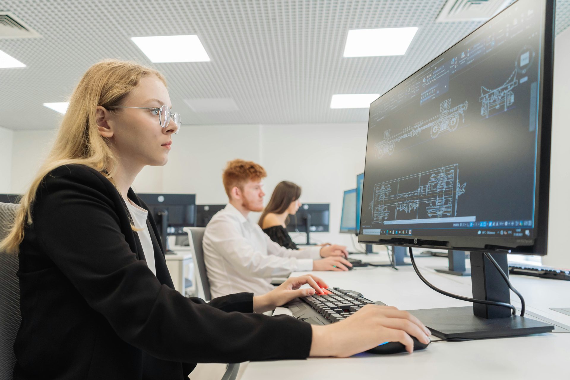a woman sitting in front of a computer monitor